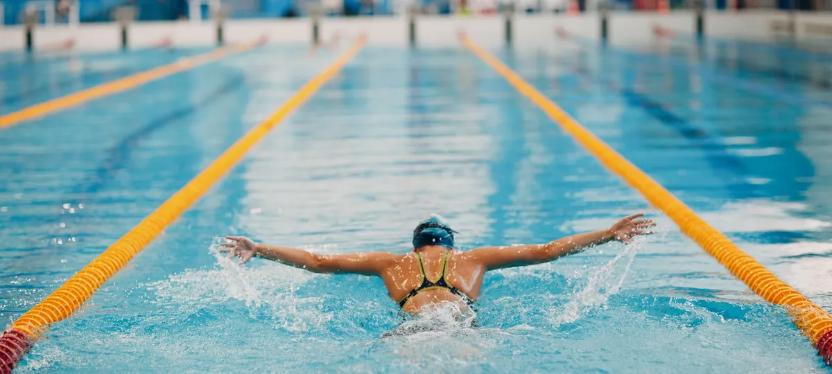 Young woman swimmer training in swimming pool