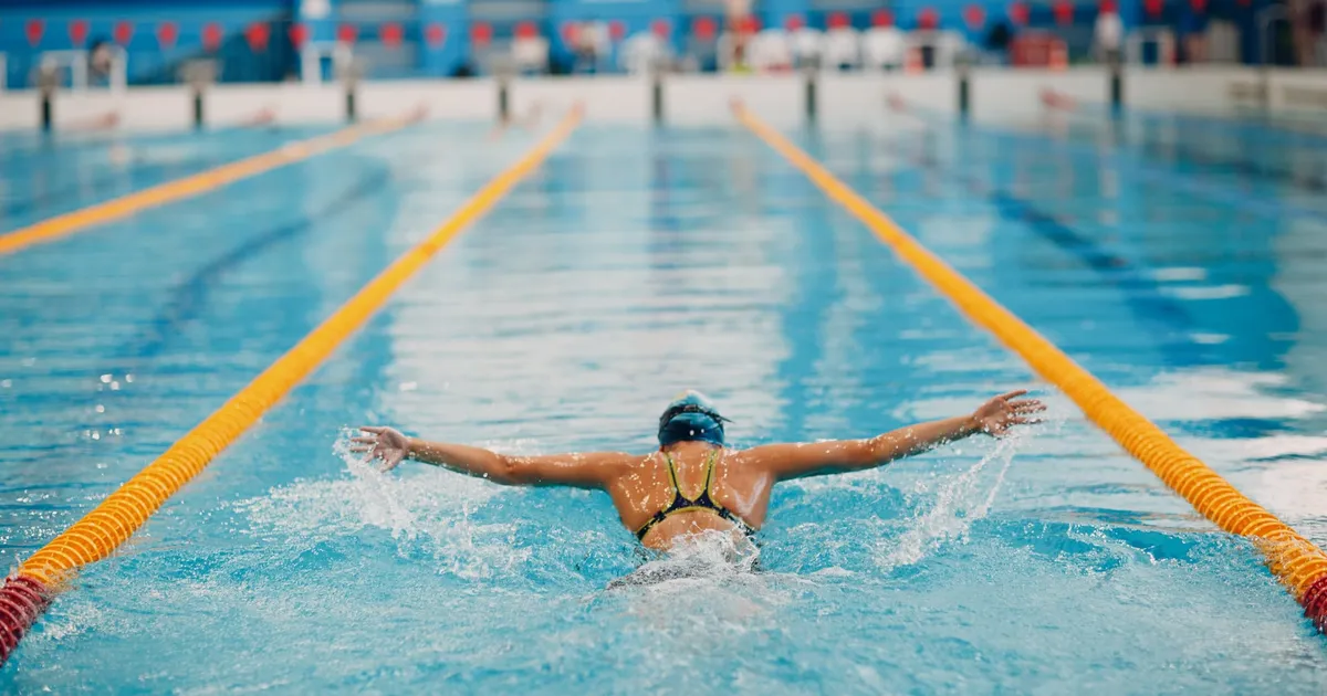 Young woman swimmer training in swimming pool